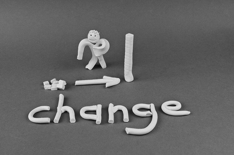 Clay model of person stacking blocks up into a pile to show change