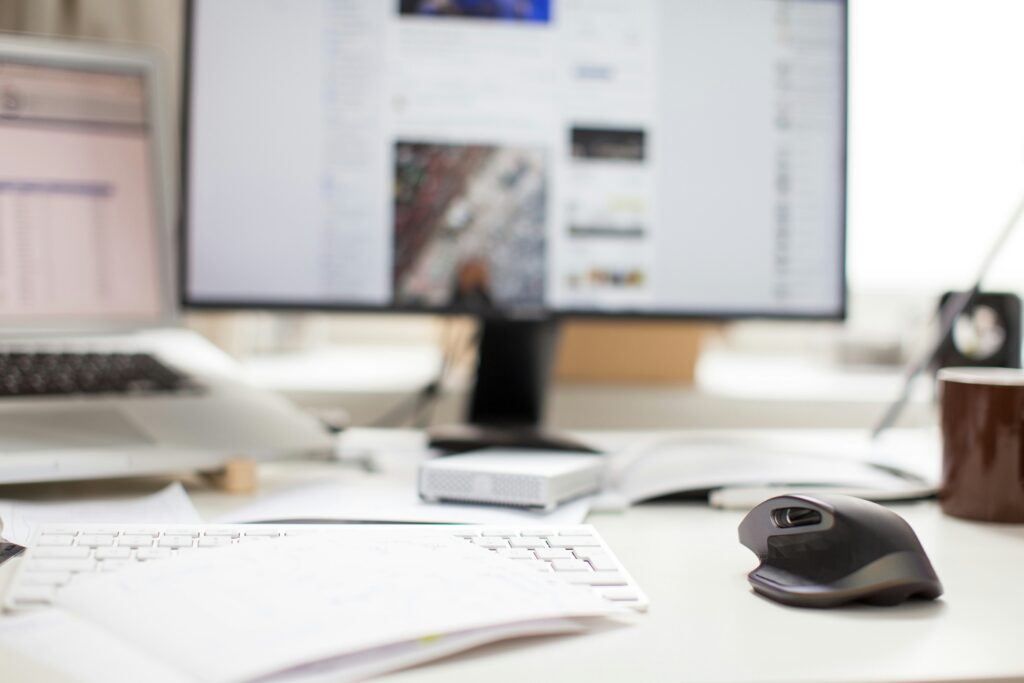 image of paperwork in the foreground, background is a blurred computer