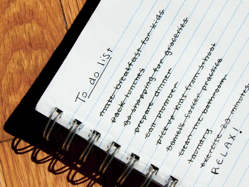 A notebook, open on a to do list. All the items are crossed out, except for RELAX! In capital letters