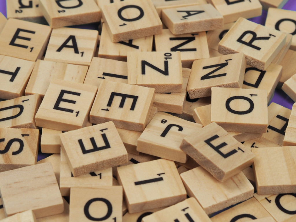Jumble of letter tiles (like scrabble) scattered across a table. Symbolising the scramble that can hapen to someone with dyslexia reading, listening or learning