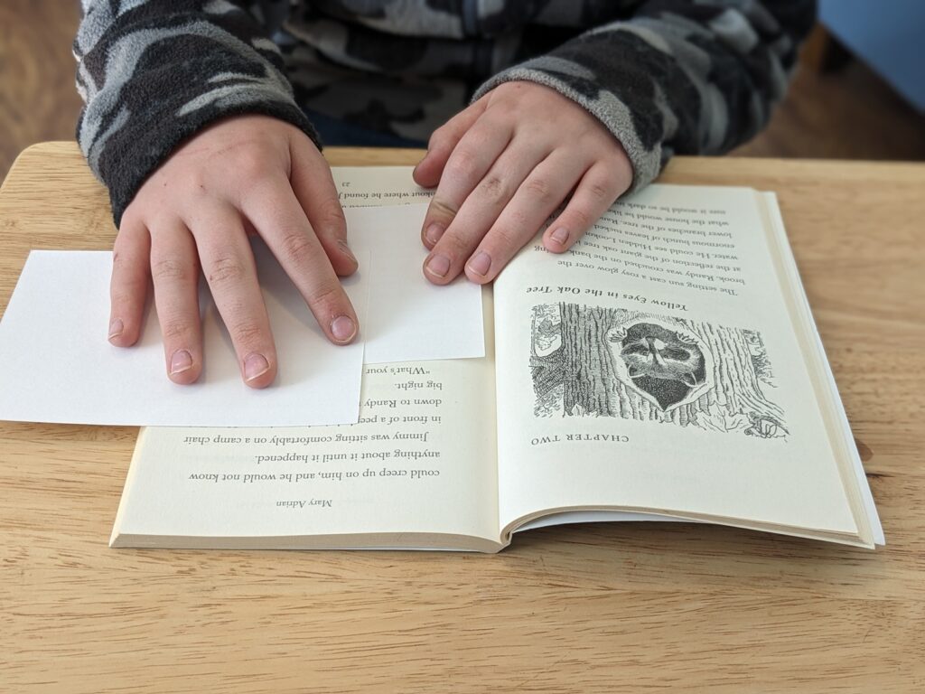 An open book, with paper covering parts of the text. This is sweep, sweep, spell