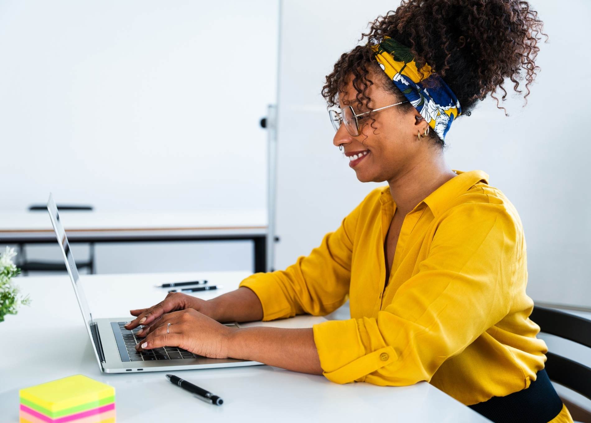 Woman of colour sitting at a desk on her laptop