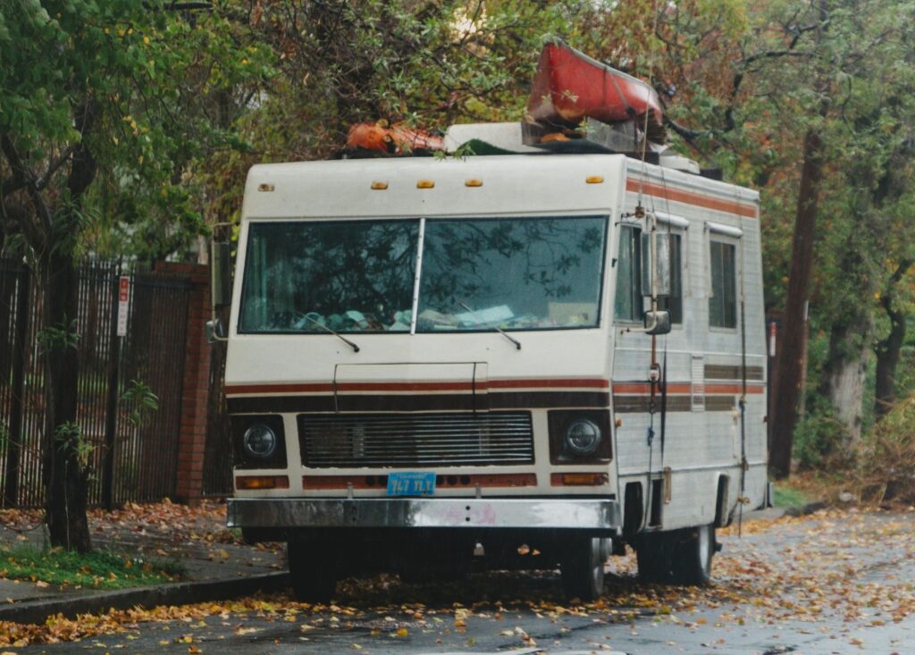  older RV parked on the side of the road in a suburban area